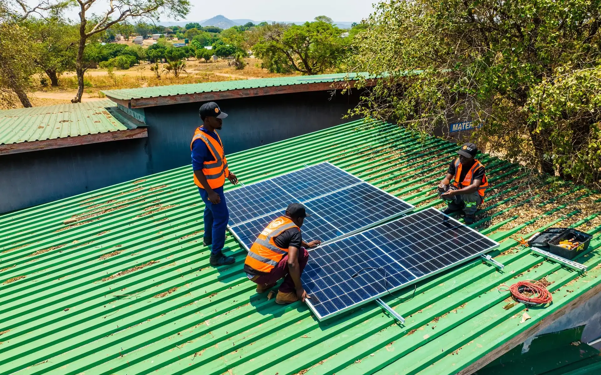 EcoHive technicians fitting solar panels on the roof of Palabana Clinic