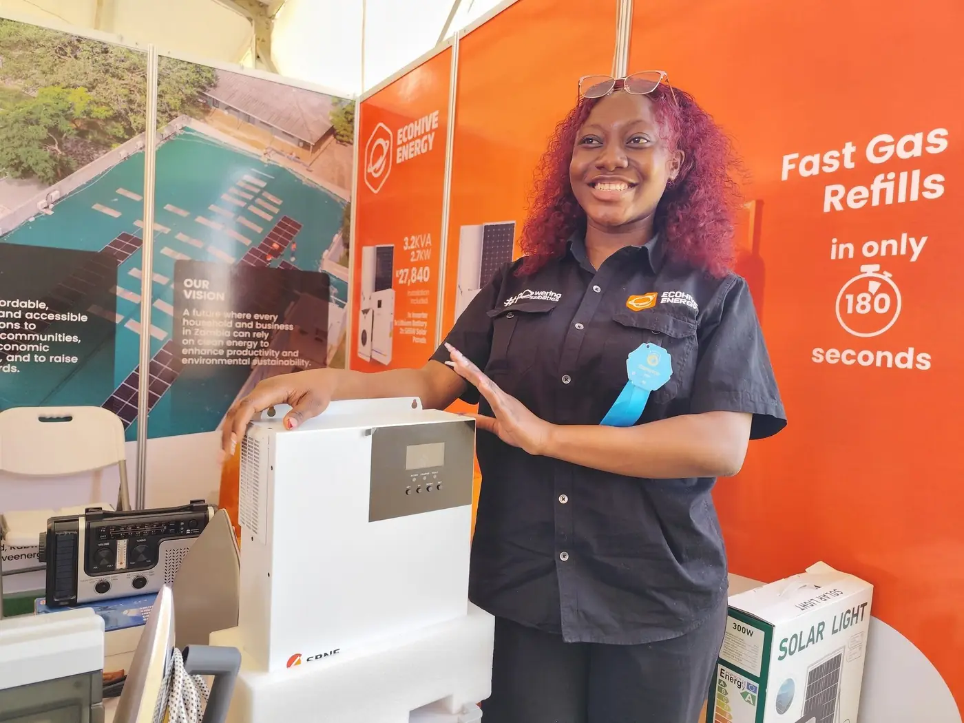 An EcoHive team member presenting a home inverter at the EcoHive stand