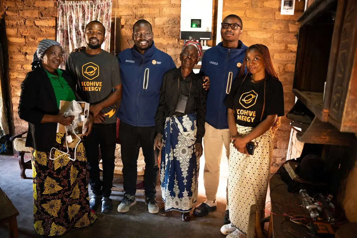 EcoHive staff and Lazaro Village residents together inside a newly powered home