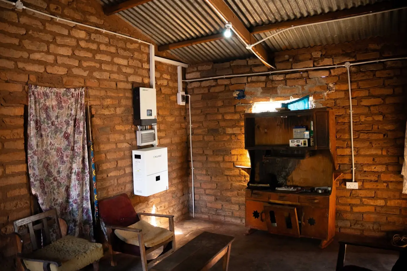 A wall-mounted inverter and battery inside a Lazaro Village home